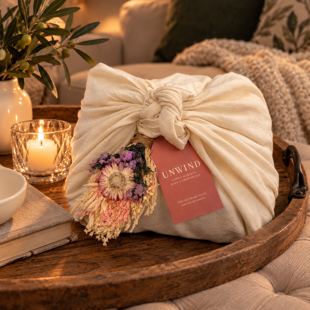 Unwind gift set wrapped in a cream cotton tea cloth with dried florals and a coral hang tag